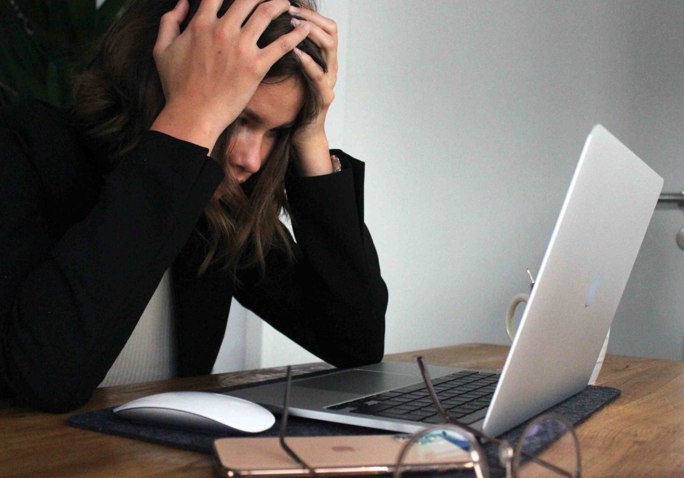 Donna al computer sopraffatta che non riesce a gestire lo stress da debito