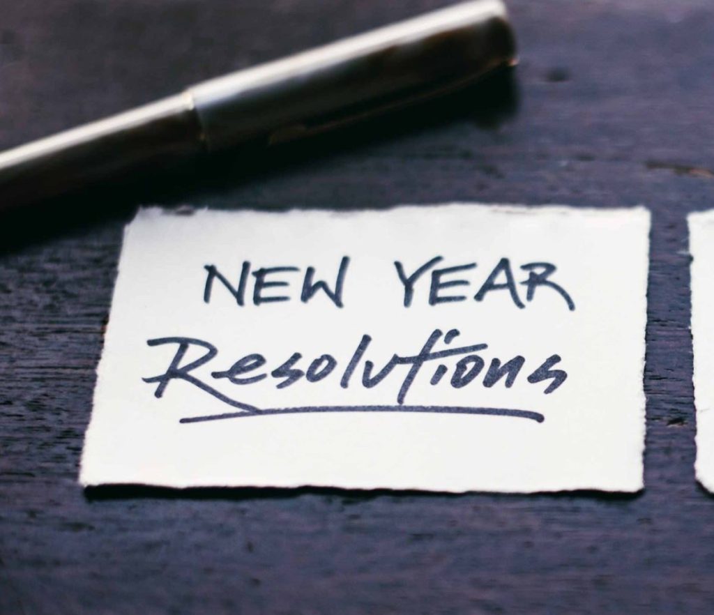 New Year resolution scritto con un pennarello nero su foglio bianco: scrivi anche tu i tuoi obiettivi