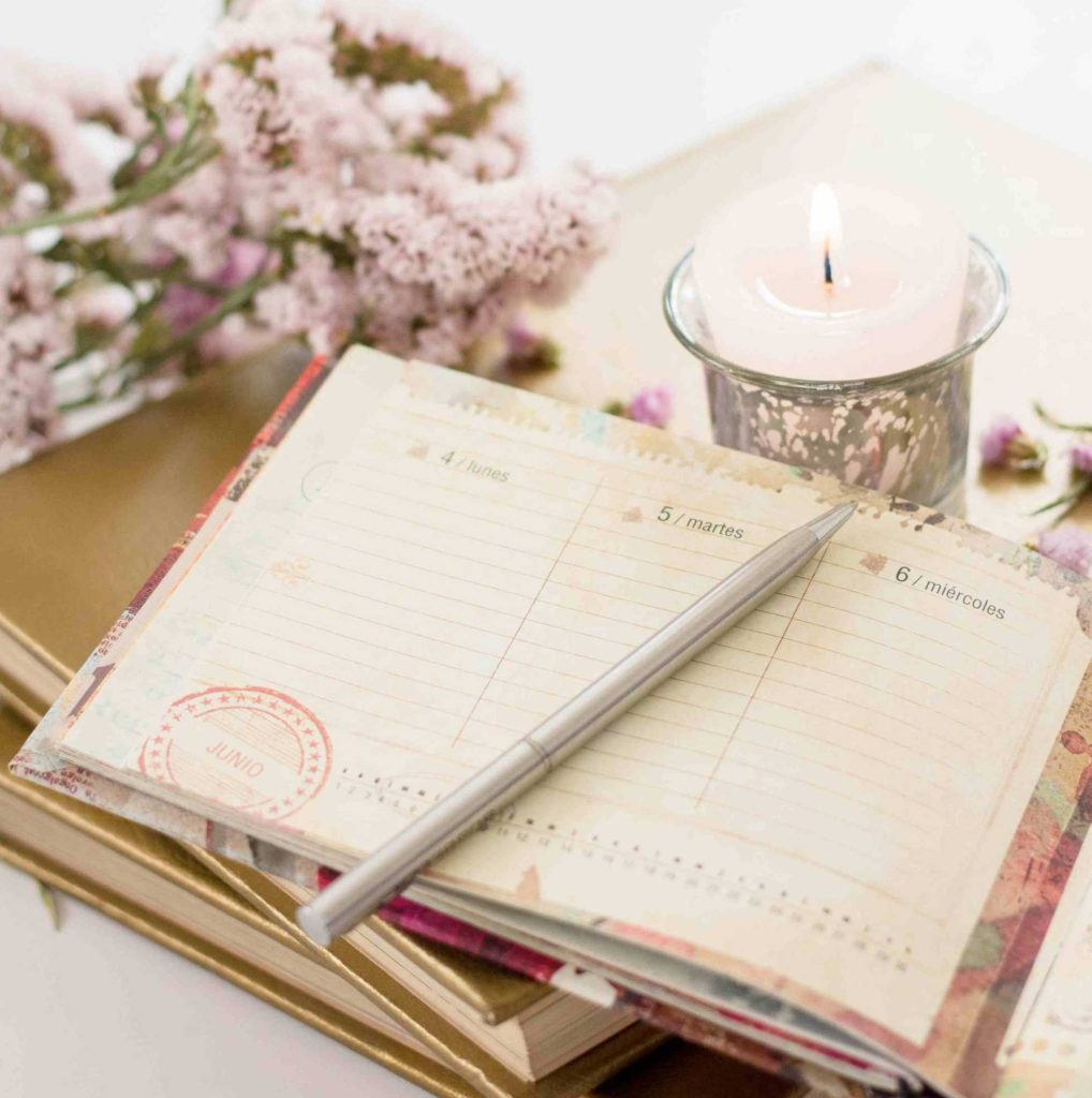 Budget 80/20 con leggerezza, un solo quaderno, una bella penna dorata, una candela profumata e qualche fiore delicato, tutto sui toni del rosa chiaro come nell'immagine, per un pizzico di sano romanticismo