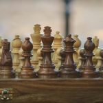 Scacchiera con pezzi in legno chiaro e scuro: una challenge di risparmio è sfida come in una partita a scacchi