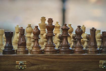 Scacchiera con pezzi in legno chiaro e scuro: una challenge di risparmio è sfida come in una partita a scacchi