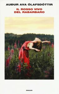 Copertina del libro "Il rosso vivo del rabarbaro" con una fotografia di una giovane donna in vestito rosso in un campo di rabarbaro che alza le braccia al cielo in segno di libertà, su sfondo bianco. In alto il titolo in rosso e sopra in nero, l'autore.